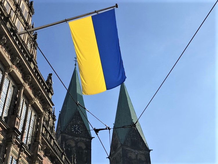 Die Flagge der Ukraine vor zwei Kirchtürmen