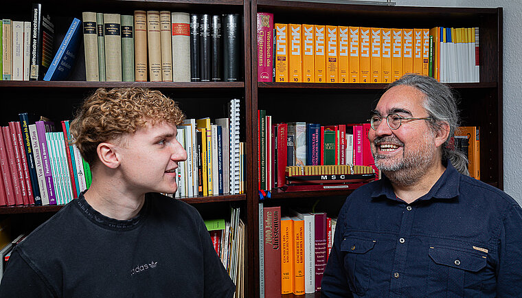 Moritz Kracht und Oliver Rosteck vor einem Bücherregal.